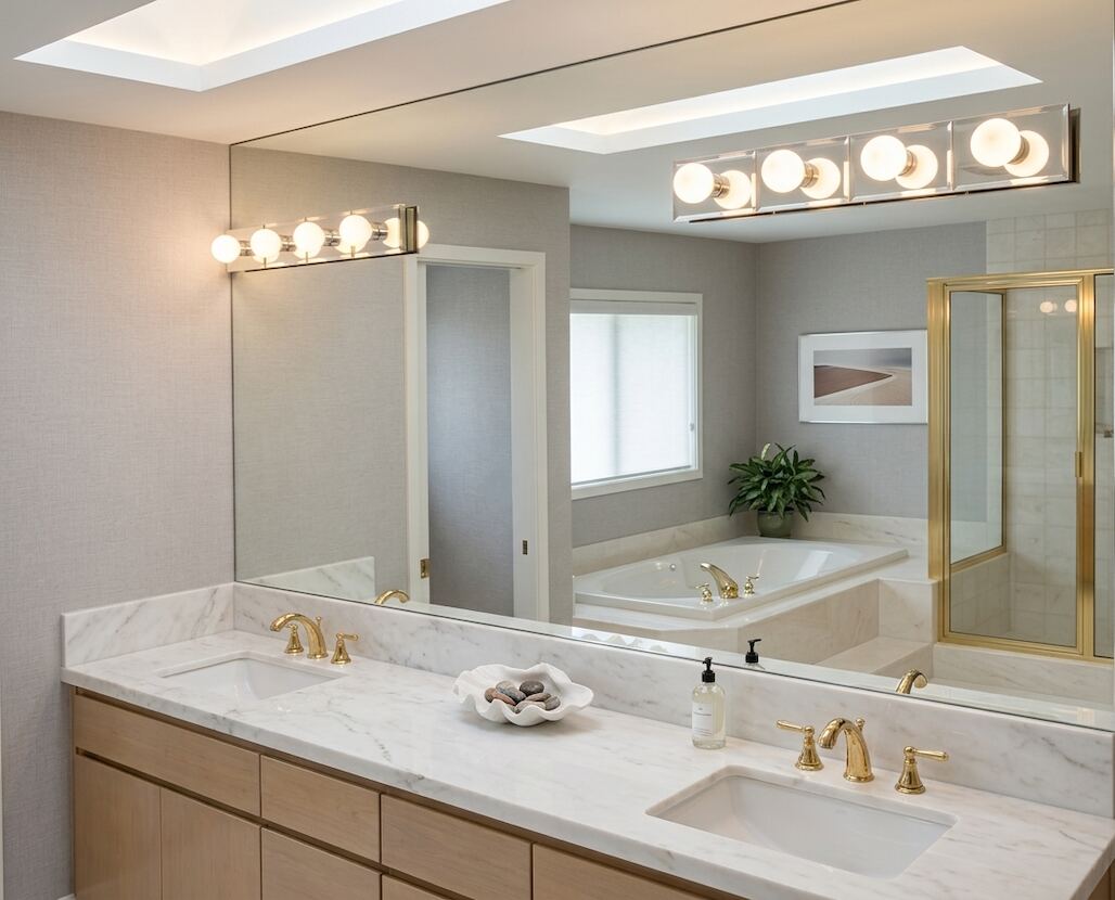 Bathroom vanity remodel with double sinks, marble-look counter, tub, shower, and updated lighting