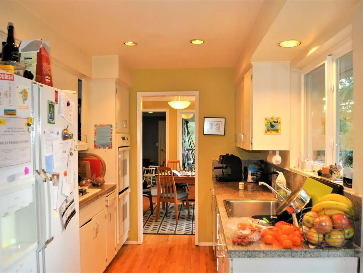 Before photo of a narrow kitchen with older cabinets, limited counter space, and no island